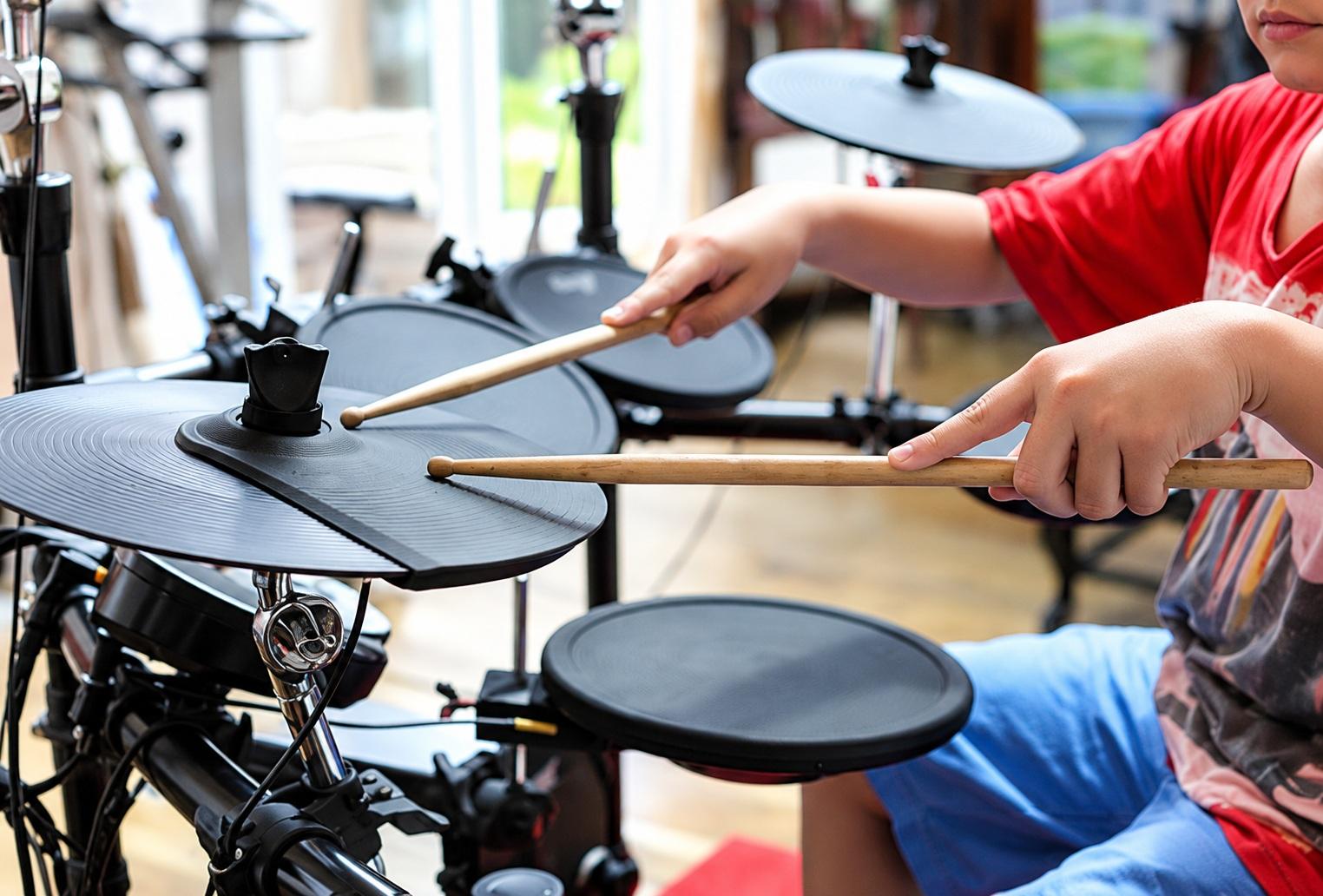 Learner practising on an electronic drum kit